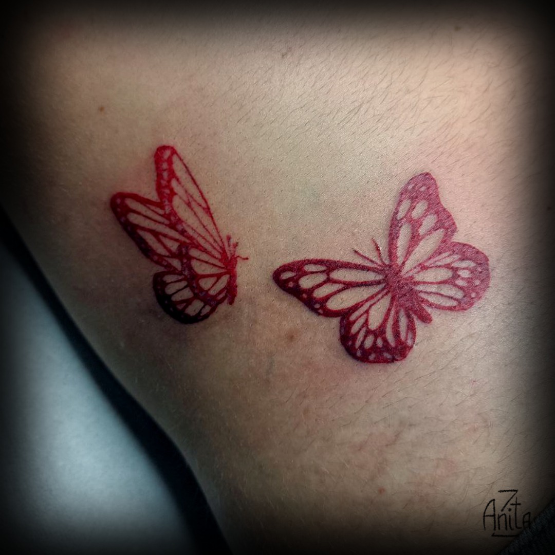Tatuaggio fineline rosso farfalle per donna su fianco